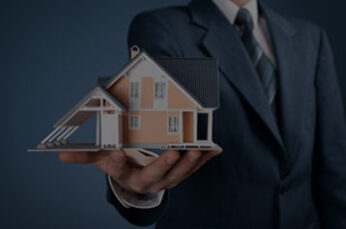 Image of man holding a model home to represent Real Estate Law