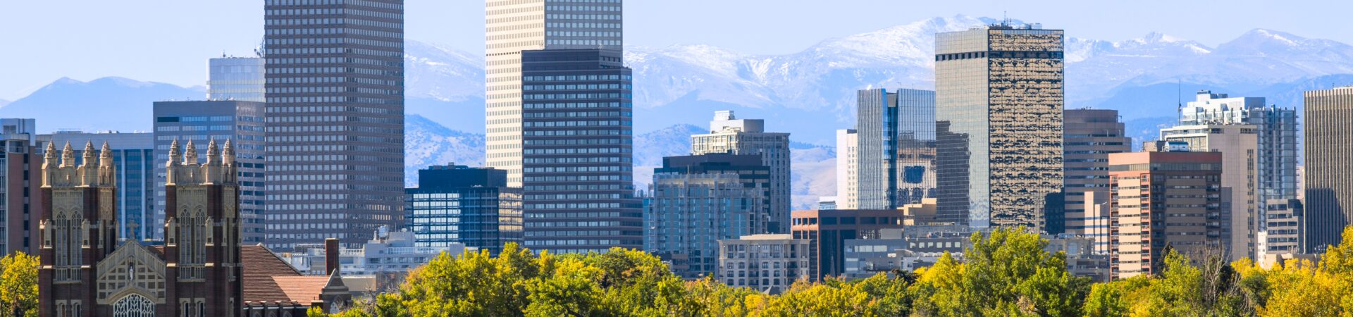 Image of downtown Denver skyline and Rocky Mountains in the background.